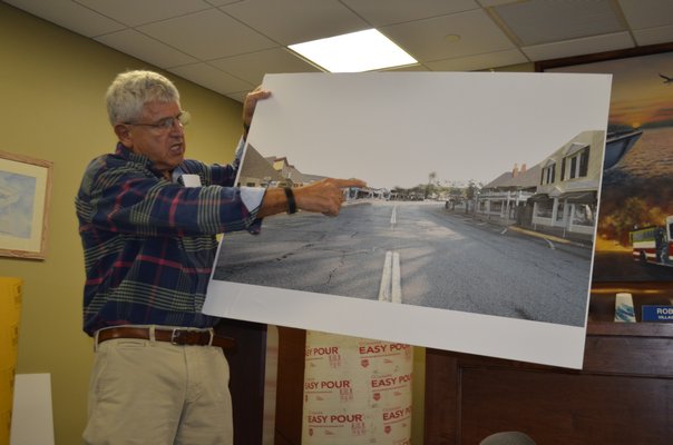 Sandpebble's owner, Victor Canseco, showing photos of what the reconstruction project will look like while it is underway. ANISAH ABDULLAH
