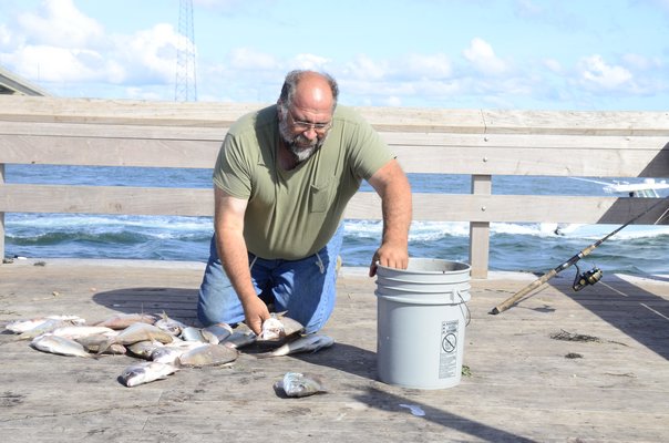 Paul Ripperger of West Islip counted the number of porgie he caught from the Old Ponquogue Bridge Pier on Friday morning. GREG WEHNER