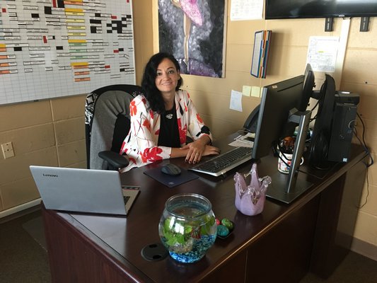 DR. Greenberg sits at her desk in her new office.
