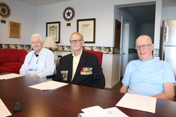From left, centennial journal writer David Nimz, editor Franky Doty and Robert Browngardt, a Legion member with many family connections in the post’s past, were on hand at the Legion Hall recently to talk about the post and the journal project.