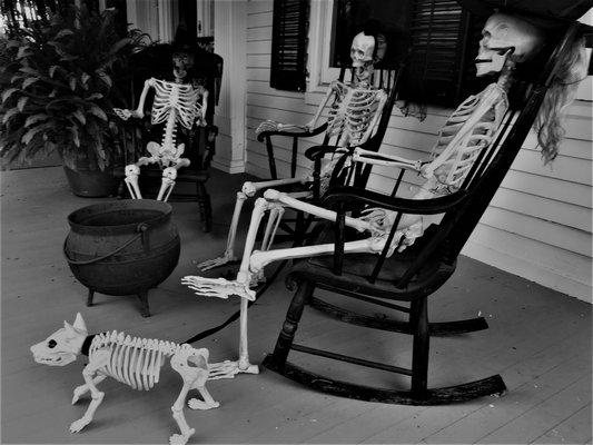 Four skeletons on the porch of the haunted Rogers Mansion.