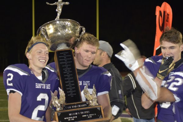 Lucas Brown (2) and Quinn Smith walk the Mayor's Cup to their end zone to celebrate with the rest of their teammates.