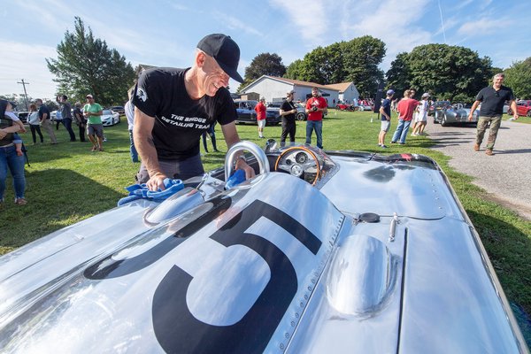 Doug Cunningham of Absolute Shine Auto Spa does some detailing on a Christopher Runge hand-built aluminum 1964 Model 356 Porsche during the Bridgehampton Cars & Coffee event hosted by The Bridge on the grounds of the Bridgehampton Museum on Sunday morning.  MICHAEL HELLER