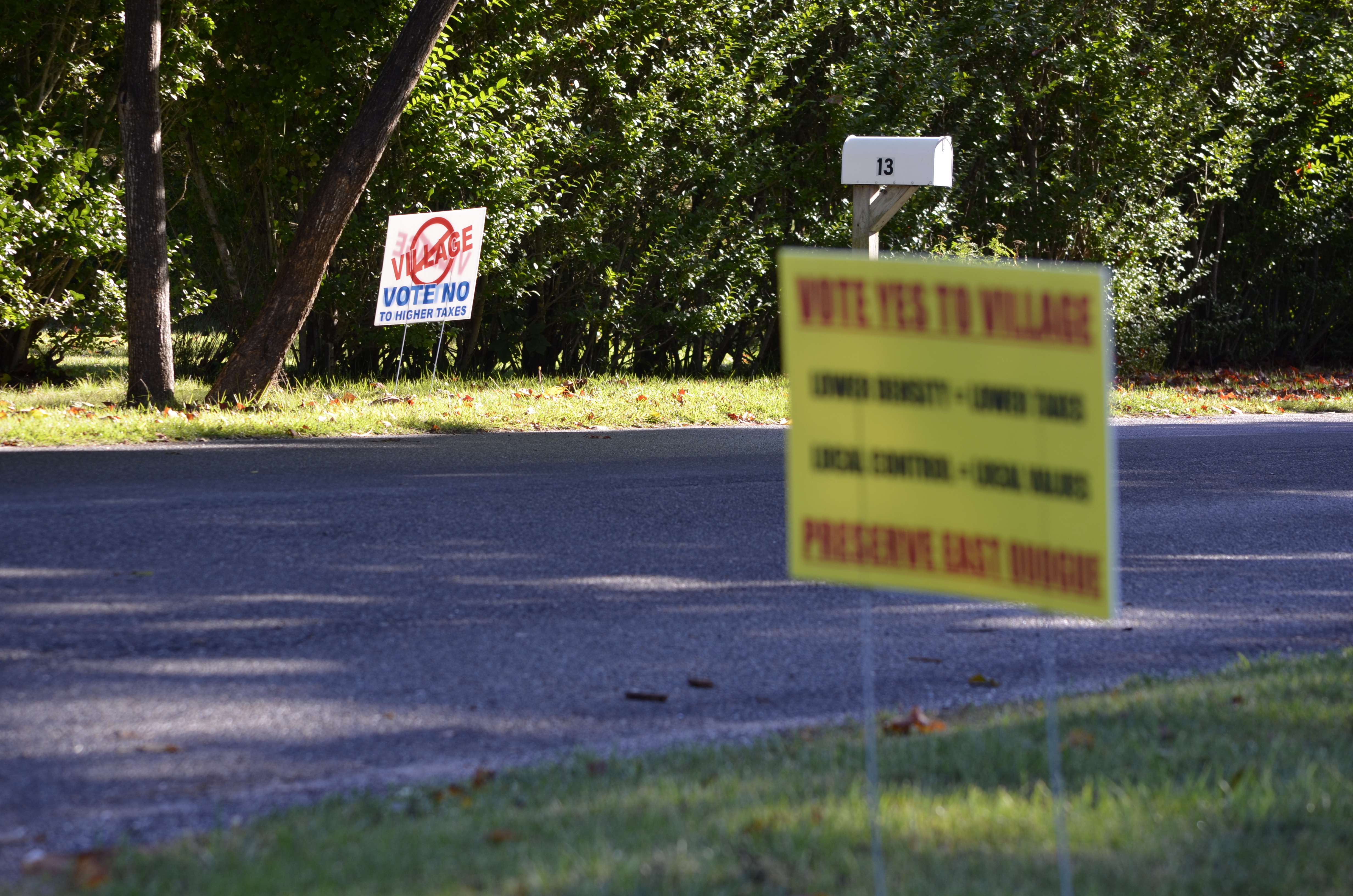Signs for and against the East Quogue village incorporation are posted across the street from each other. ANISAH ABDULLAH