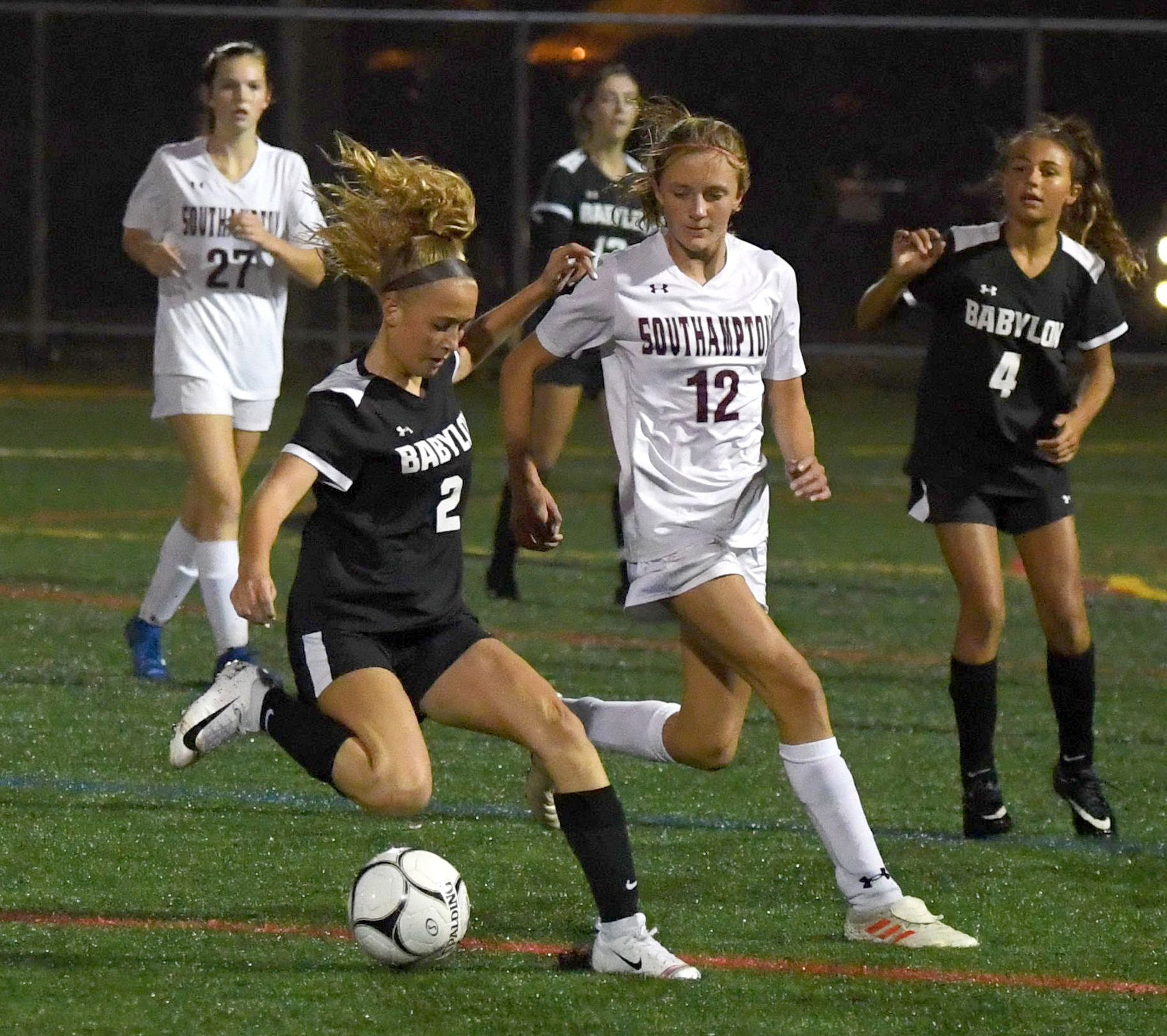 Southampton freshman Juliette Archer (12) stays on the hip of Babylon's Kate Ficken as she reverses course near midfield.