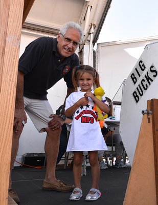 The Montauk Fire Department's annual Big Bucks event is always a big draw. Hundreds turned out on Sunday for a chance to win big. Mackenzie Muscara draws a winning ticket with help from Tom Grenci. KYRIL BROMLEY
