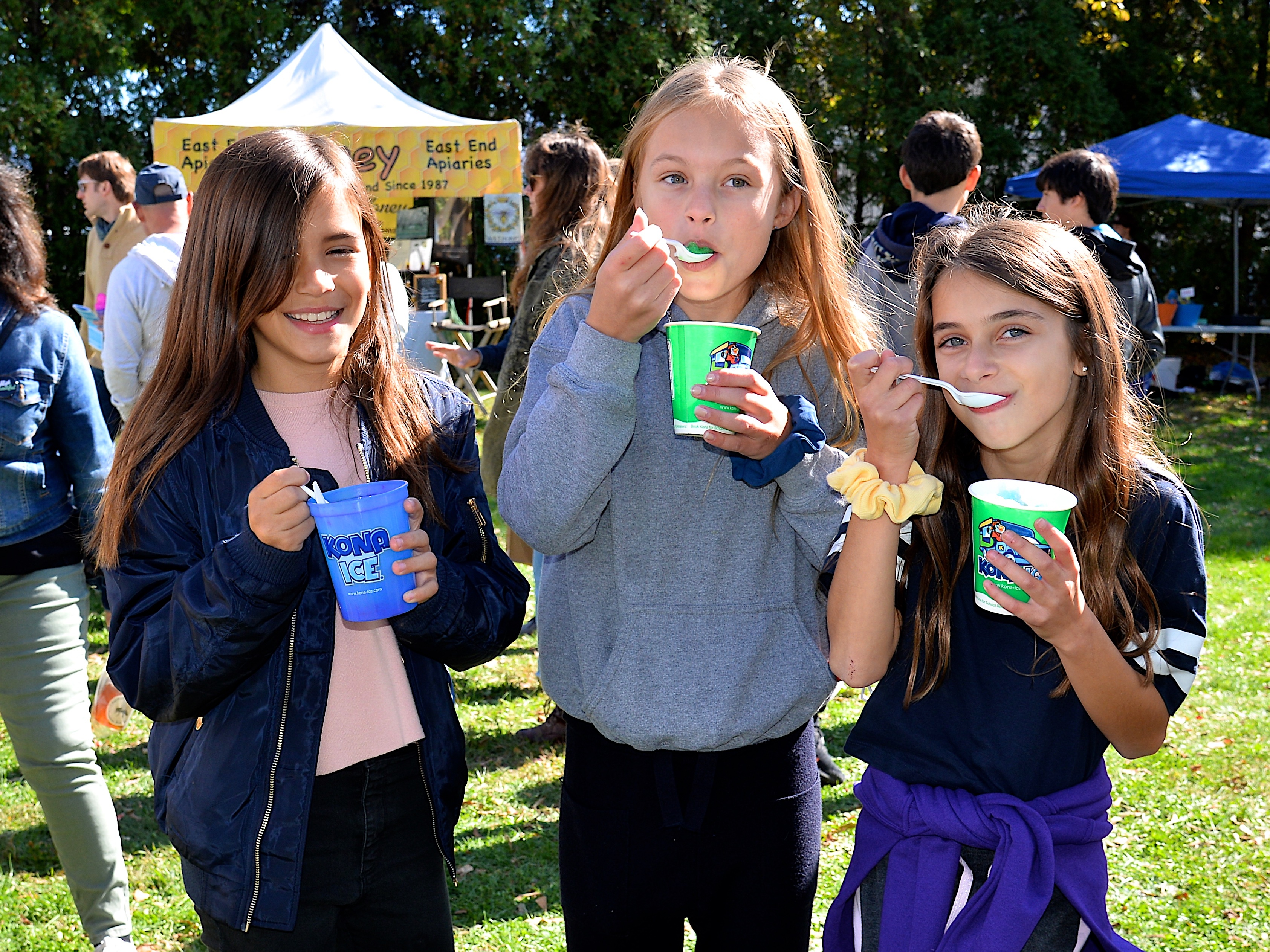 The East Hampton Chamber of Commerce hosted its Fall Festival in Herrick Park on Saturday, during which, from left, Emilia Brauer, Aislyn Short and Elizabeth Dunning enjoyed sweet treats.  KYRIL BROMLEY