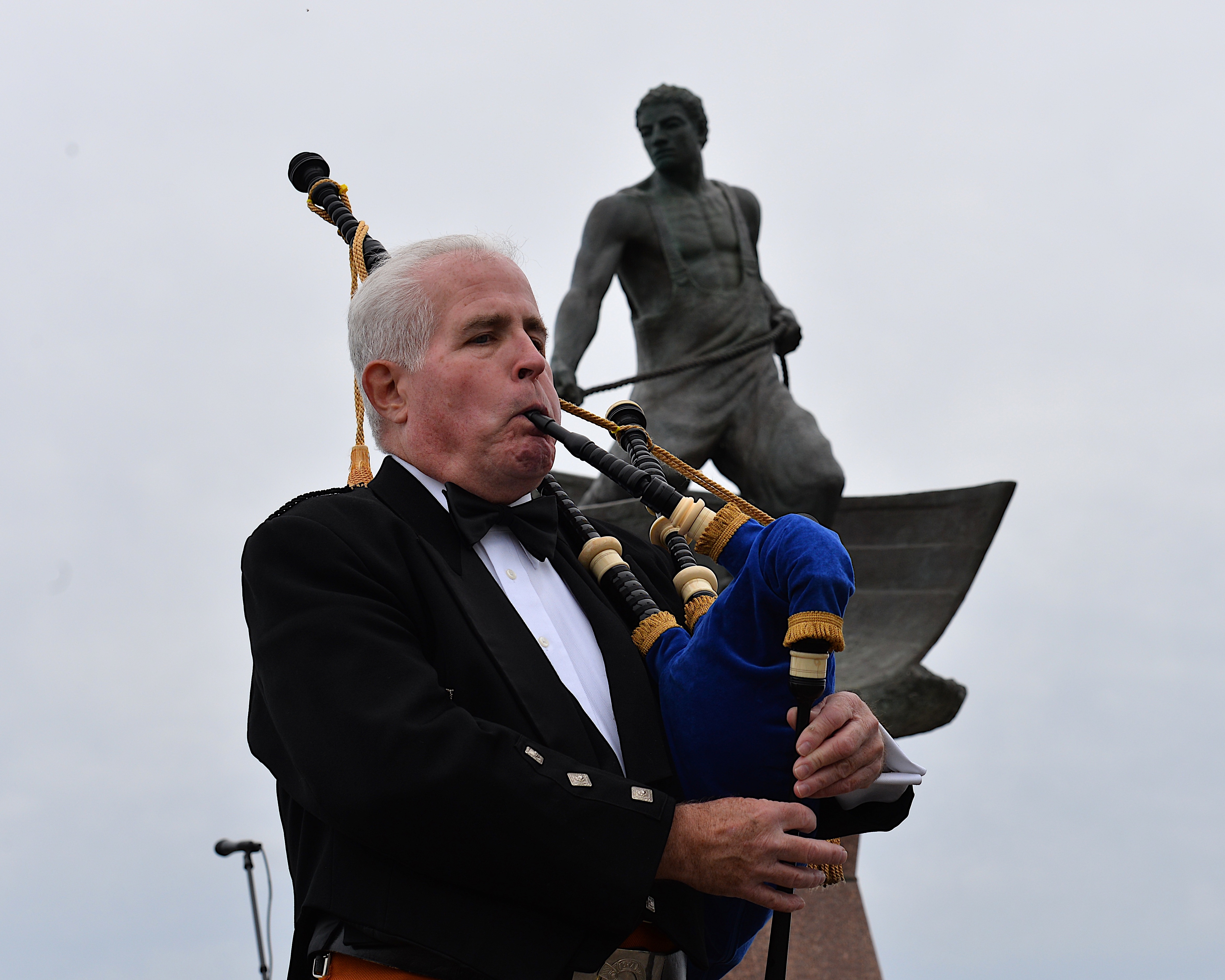 Robert Lynch plays the bagpipes at the ceremony.