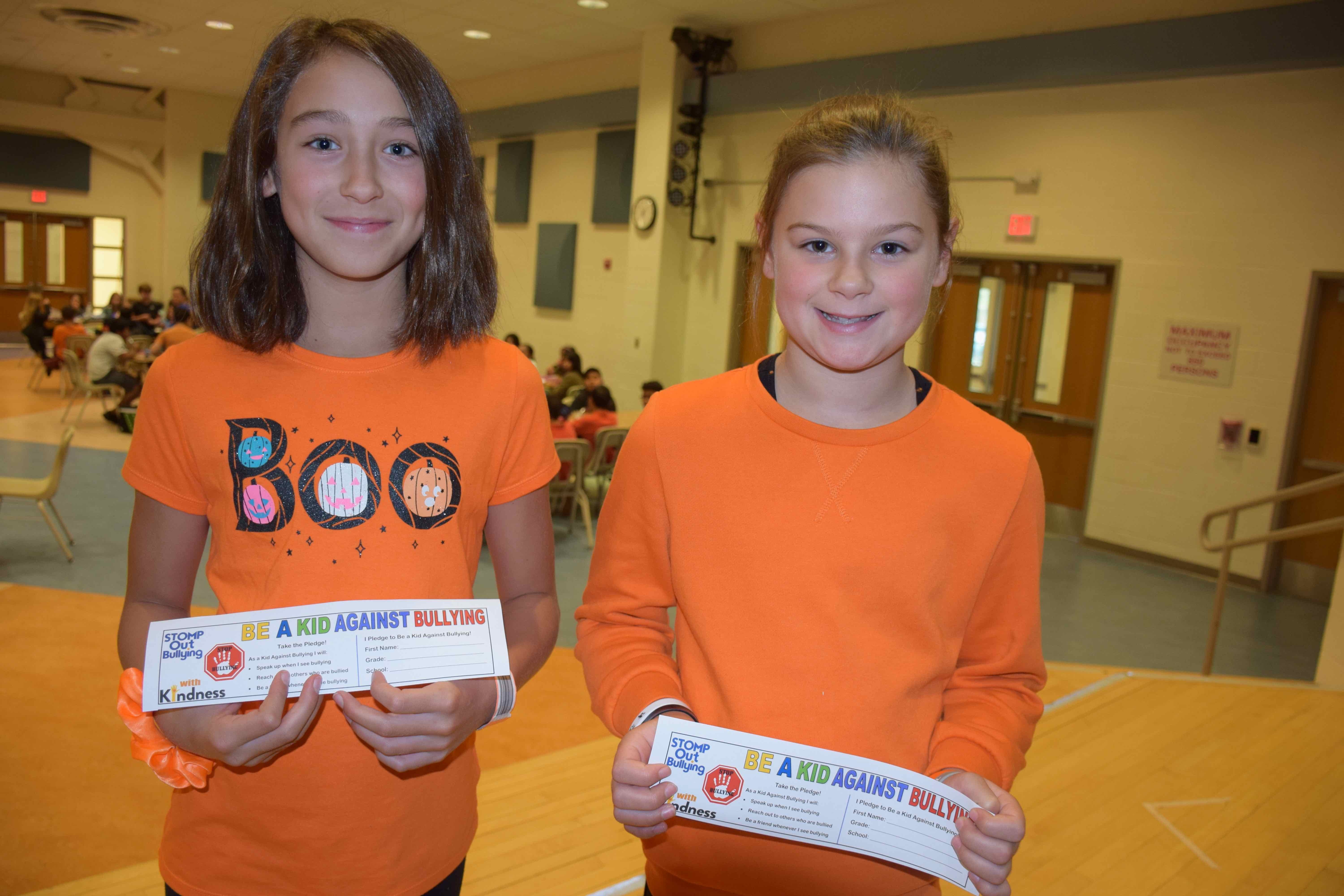 Kirra Schoerlin and Emma Schultheis, right, were among the Hampton Bays Middle School students who signed an antibullying pledge on Unity Day, October 23, following several weeks of activities in conjunction with National Bullying Prevention Month.