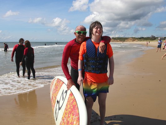 Surfers Healing, a California-based nonprofit that offers a day of surf camp for those with autism and other developmental disabilities, was at Ditch Plains in Montauk on Friday. The camp was underwritten by East End Disability Associates and receives volunteer support from the East Hampton Volunteer Ocean Rescue squad and the Montauk Lions Club. Jameson Armann with volunteer Bucky Barry. KYRIL BROMLEY