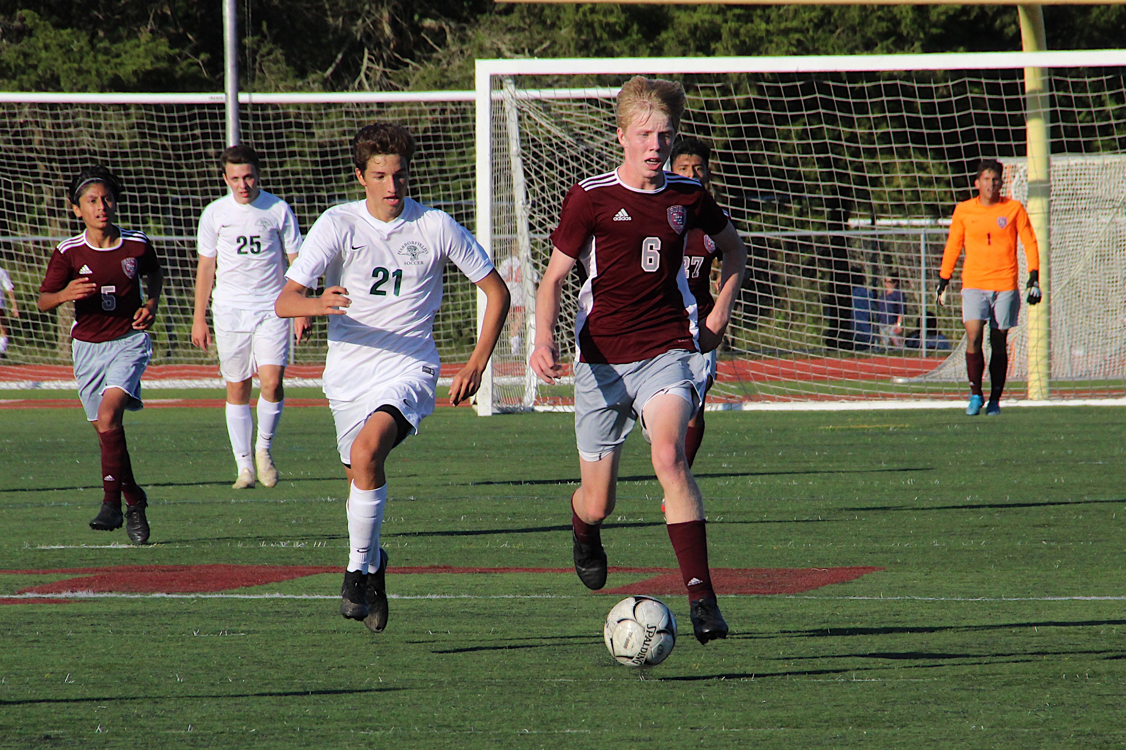 East Hampton's Matthew McGovern races the ball downfield with a Harborfields player trailing him.