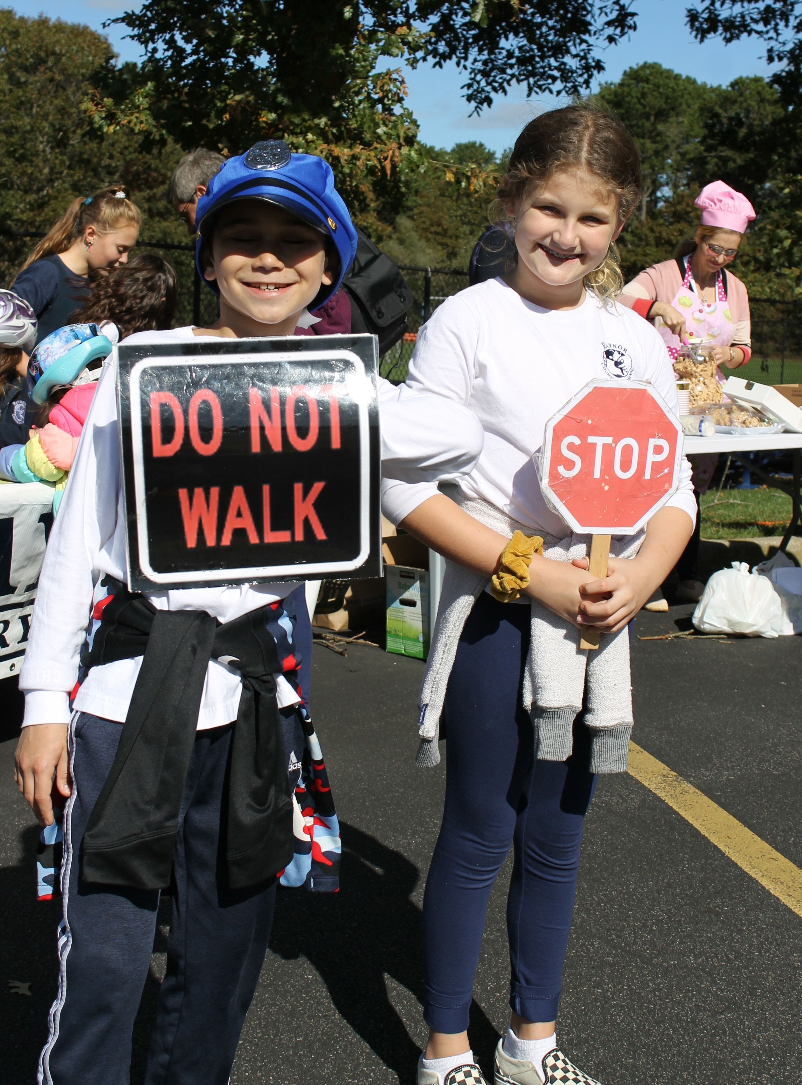 Fifth-graders Brett Geller and Chloe Gappelberg get into character as community helpers for Raynor Country Day School's annual Tykes on Bikes Safety Town Event. The event uses a fleet of tricycles and a series of challenging obstacles to promote student safety and community knowledge. Children experience a railroad crossing, a toll booth, a crosswalk, and interact with many community helpers such as firefighters, police officers, bankers, bakers, veterinarians, teachers, crossing guards, train conductors, utility workers and more.