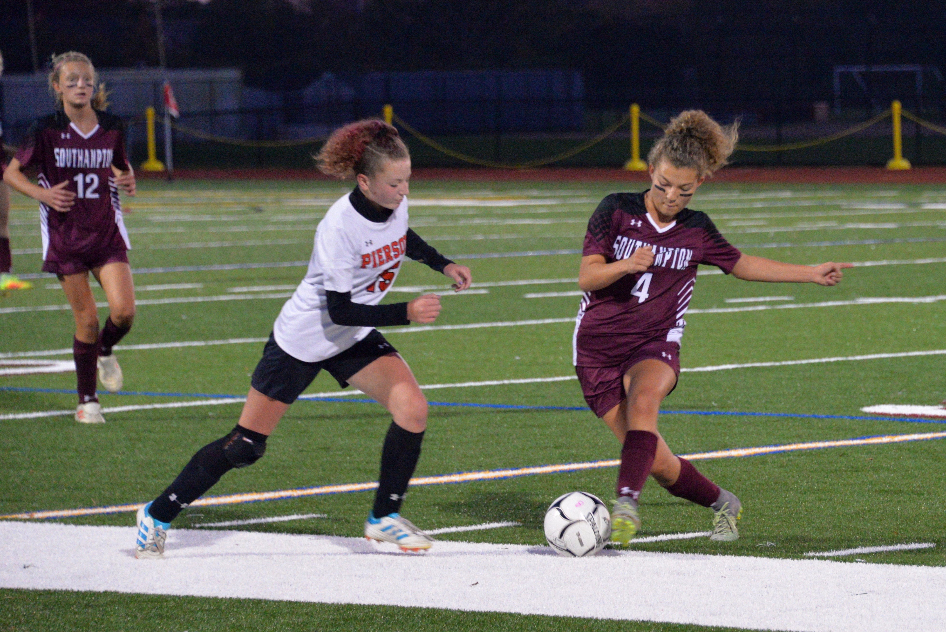 Southampton's Gabriella Arnold works the ball with Pierson's Delaina Healy on her.
