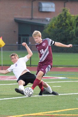 Southampton's Parker West goes to take a shot with a Greenport player bearing down on him.