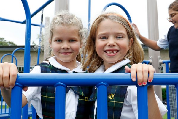 Our Lady of the Hamptons School in Southampton hosted a dedication ceremony for its new playground last week. Second-graders Ayla Cass and Lila Notley enjoy the new playground.