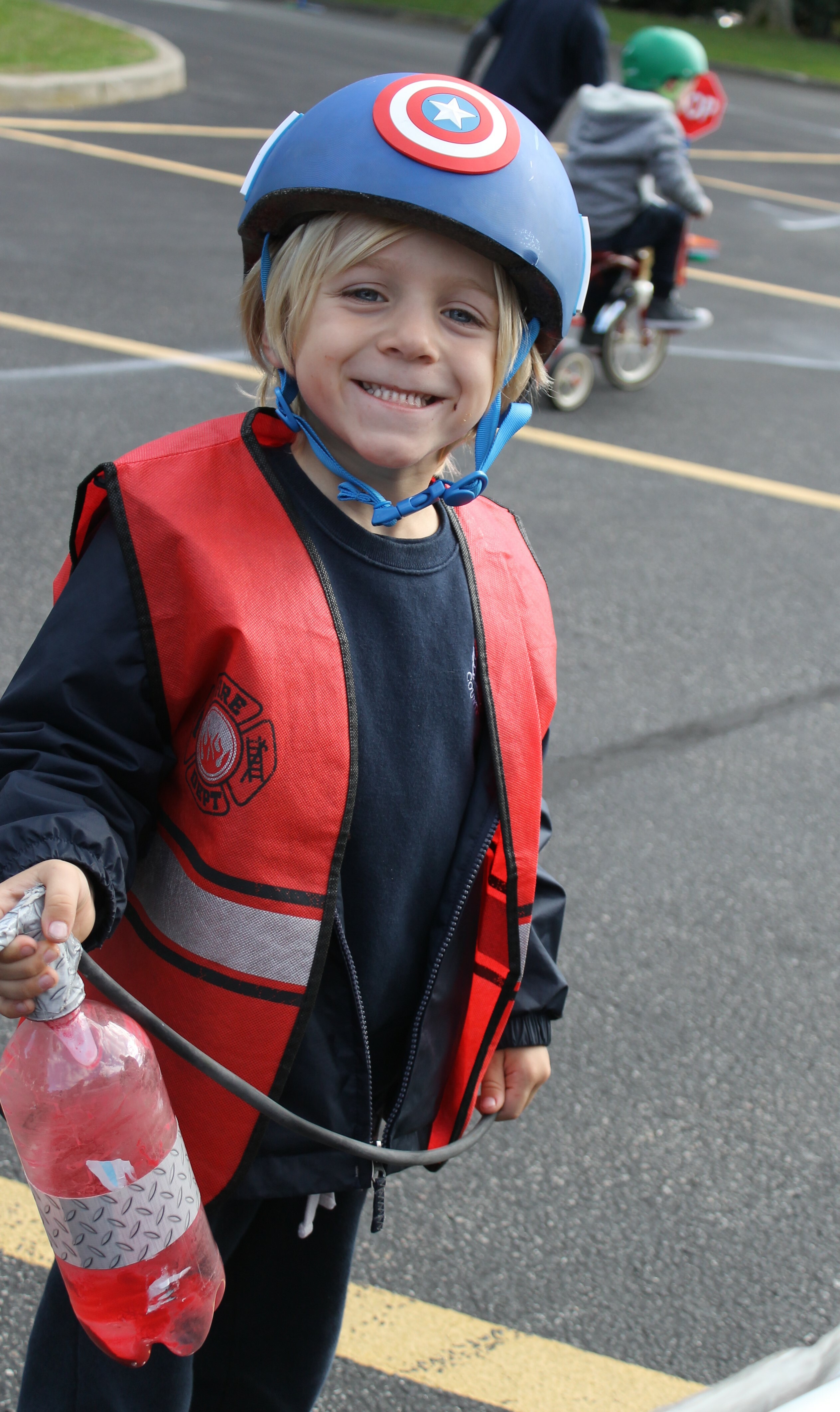 Kindergartner Porter Faulk takes a moment to visit the fire station during Raynor Country Day School's annual Tykes on Bikes Safety Town Event. The event uses a fleet of tricycles and a series of challenging obstacles to promote student safety and community knowledge. Children experience a railroad crossing, a toll booth, a crosswalk, and interact with many community helpers such as firefighters, police officers, bankers, bakers, veterinarians, teachers, crossing guards, train conductors, utility workers and more.