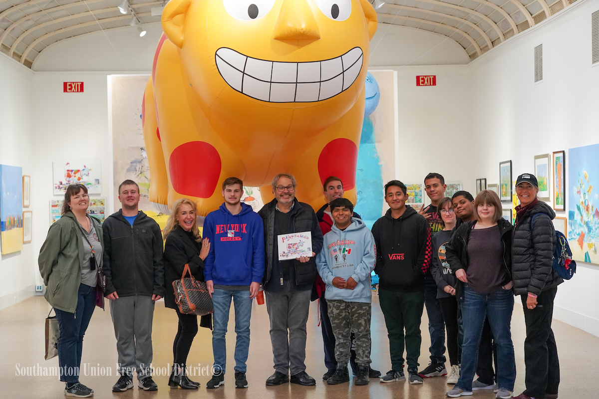 Artist Michael Paraskevas gave Southampton High School students to a tour of an exhibit of his work at the Southampton Arts Center on October 11. During the tour, the students learned more about his work as a children’s author and illustrator. He also gave each student with a hand-painted and autographed baseball cap.