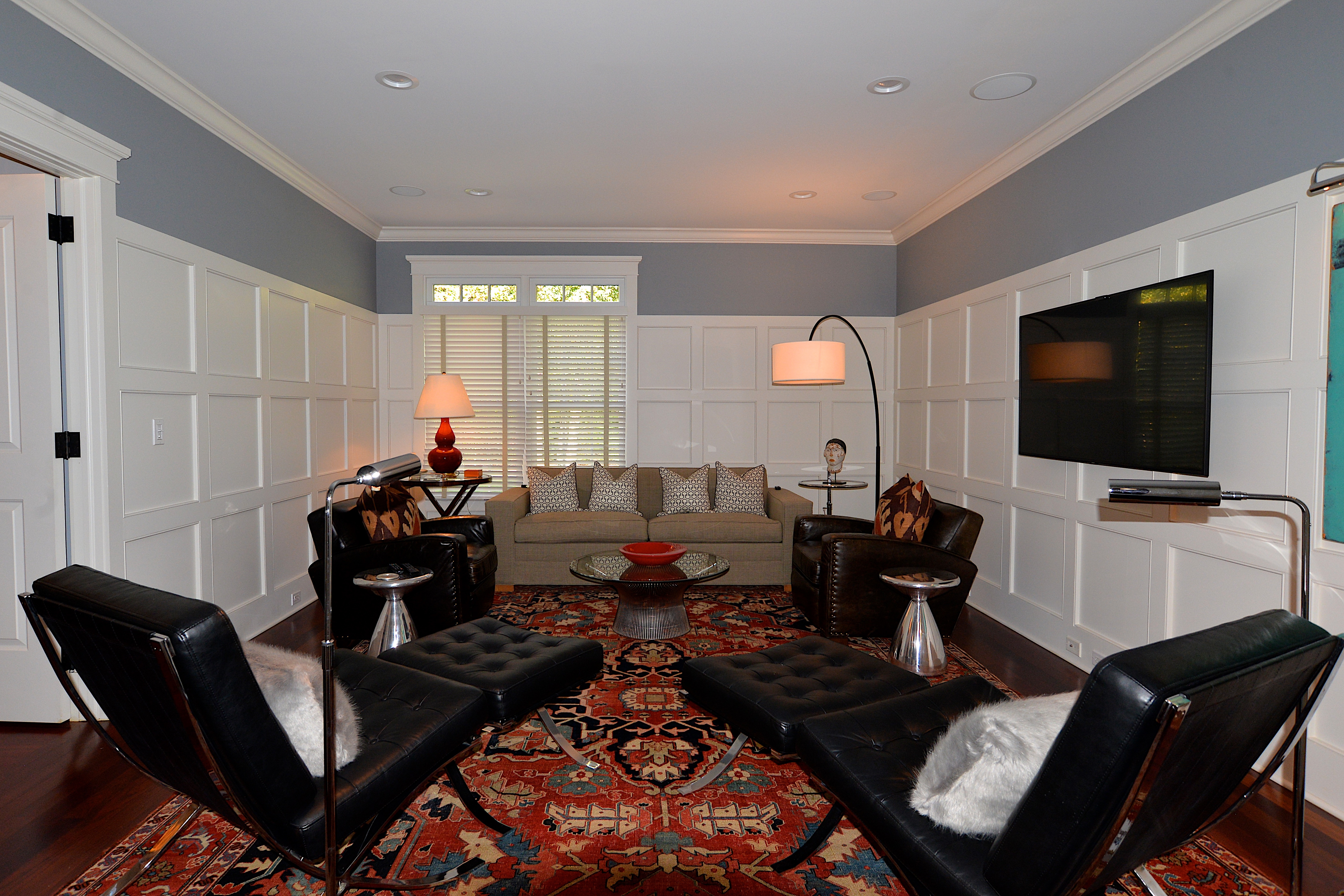 The den featured an antique Turkish rug and modern and mid-century furniture such as a Knoll table and Mies chairs.