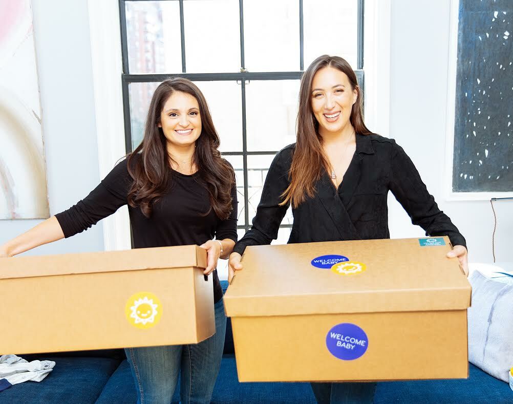 Welcome Baby co-founders, Juliet Fuisz and Sarah Steinhardt holding care packages containing all of the necessities for a newborn.   COURTESY CMEE
