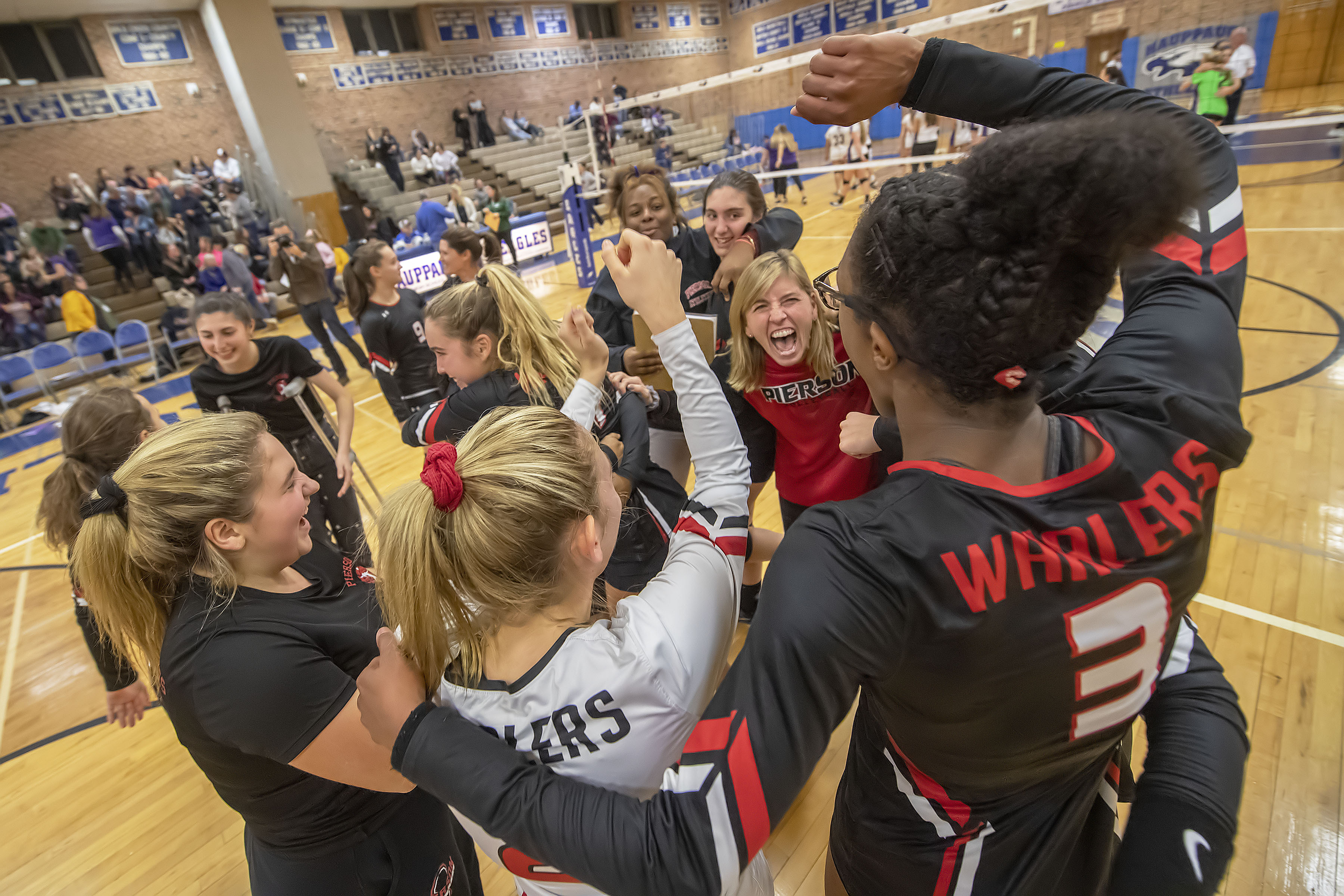 Pierson coach Donna Fisher, at center, celebrates with her team after the Lady Whalers defeated the Oyster Bay Lady Baymen to win the Long Island Class C Volleyball Championship at Hauppauge High School on Saturday night.