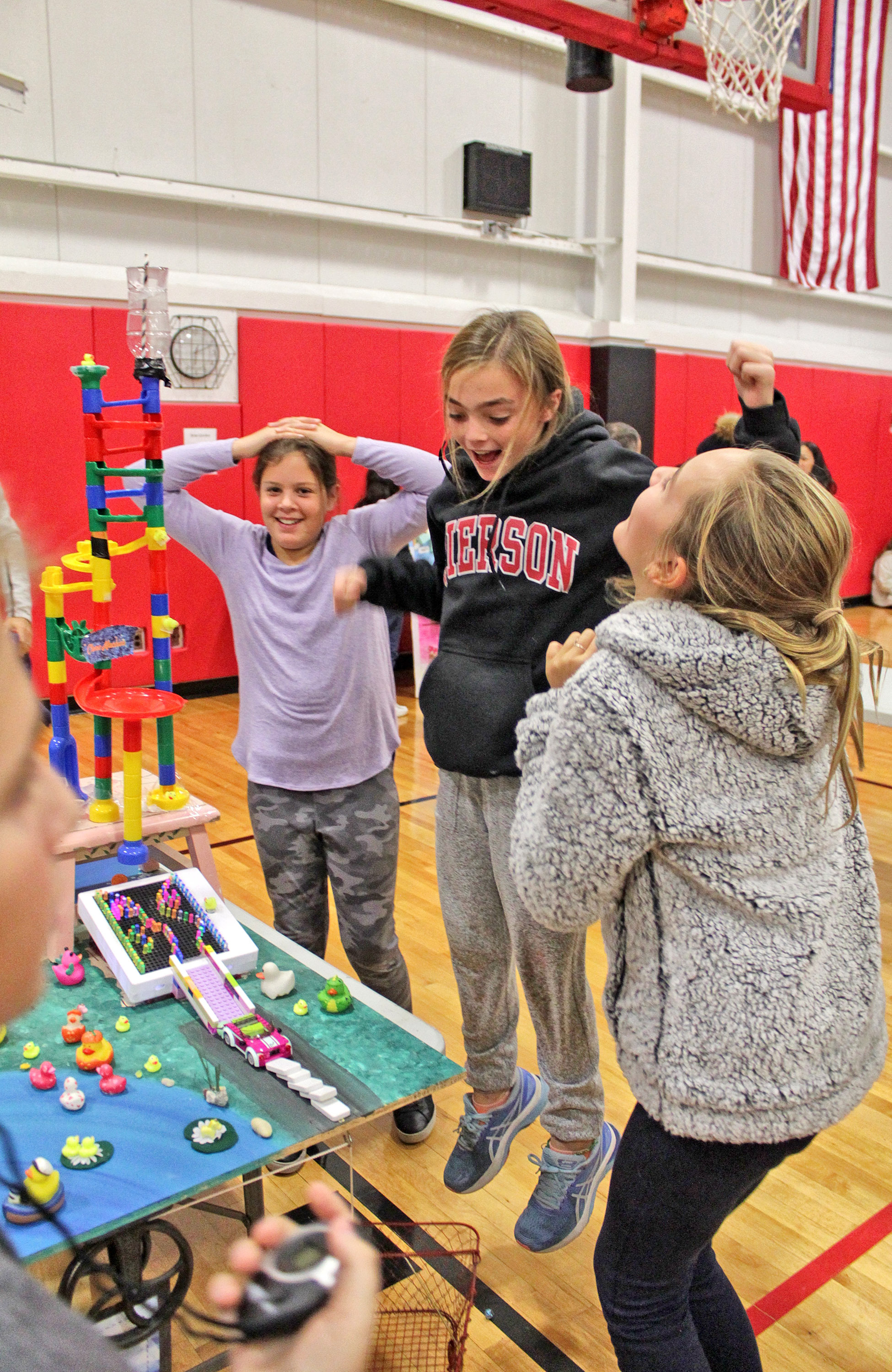 Sag Harbor Middle School students got to showcase their complicated contraptions at a Rube Goldberg Fair at school on Friday. Reese Trotter, Sabrina McManus and Virginia Kasselakis are thrilled at sucess on the third try. TOM KOCHIE