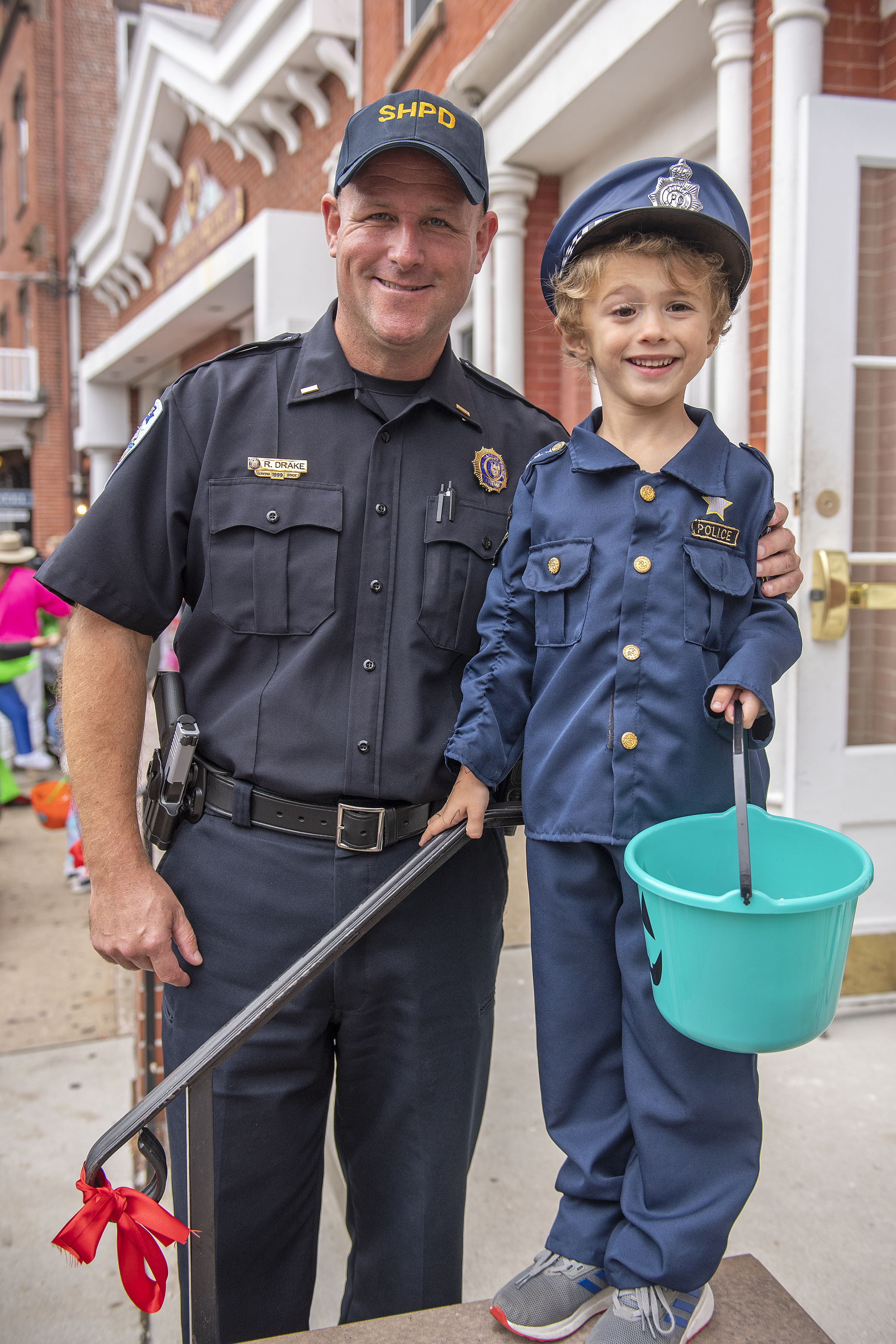Sag Harbor Village Police Lieutenant Rob Drake with his new partner, six-year-old Christopher Soloviev, during the 2019 Pumpkin Trail on Main Street on Thursday, October 31.    MICHAEL HELLER