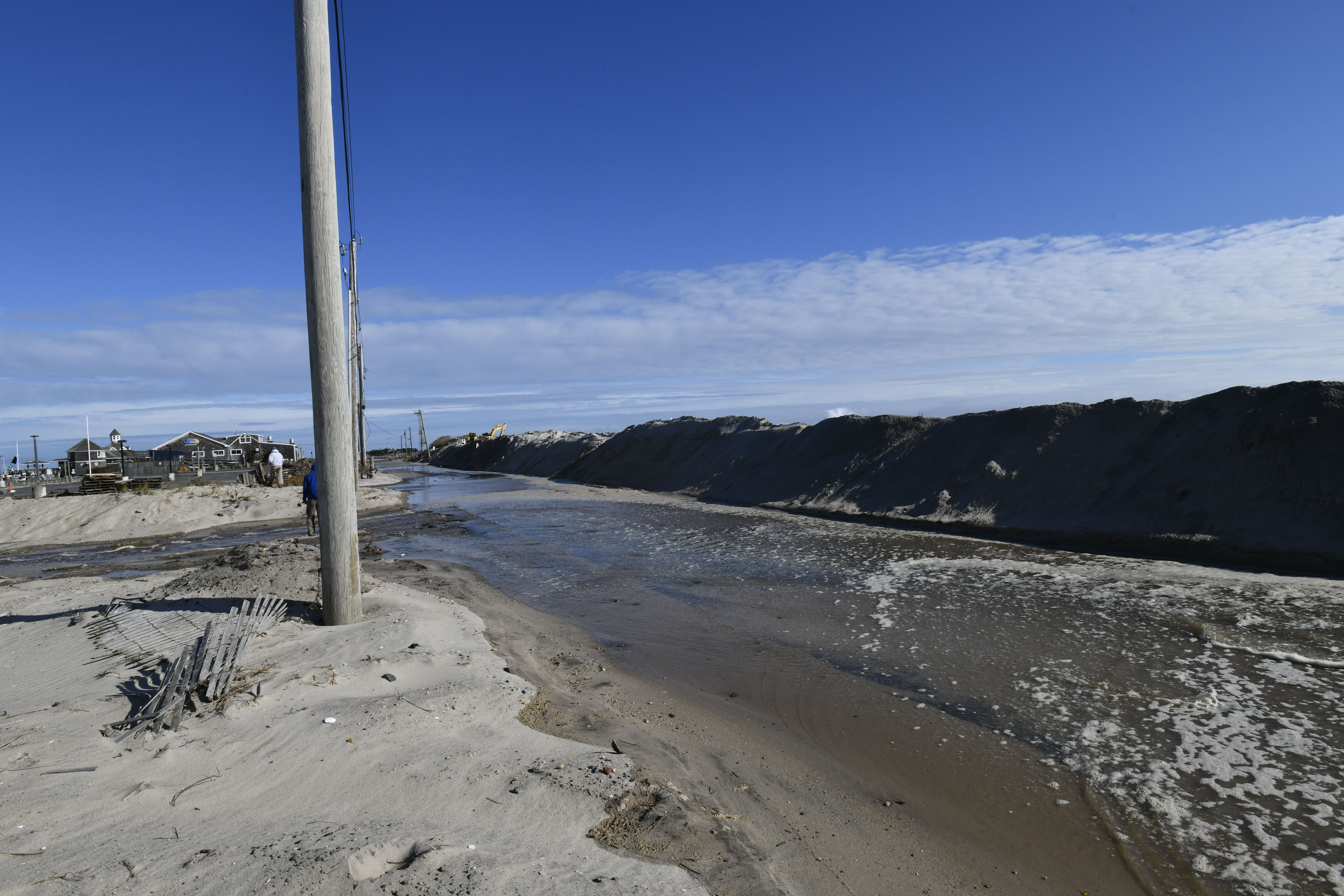 High seas wash away the dune across from the commercial fishing dock in Hampton Bays on Monday. DANA SHAW