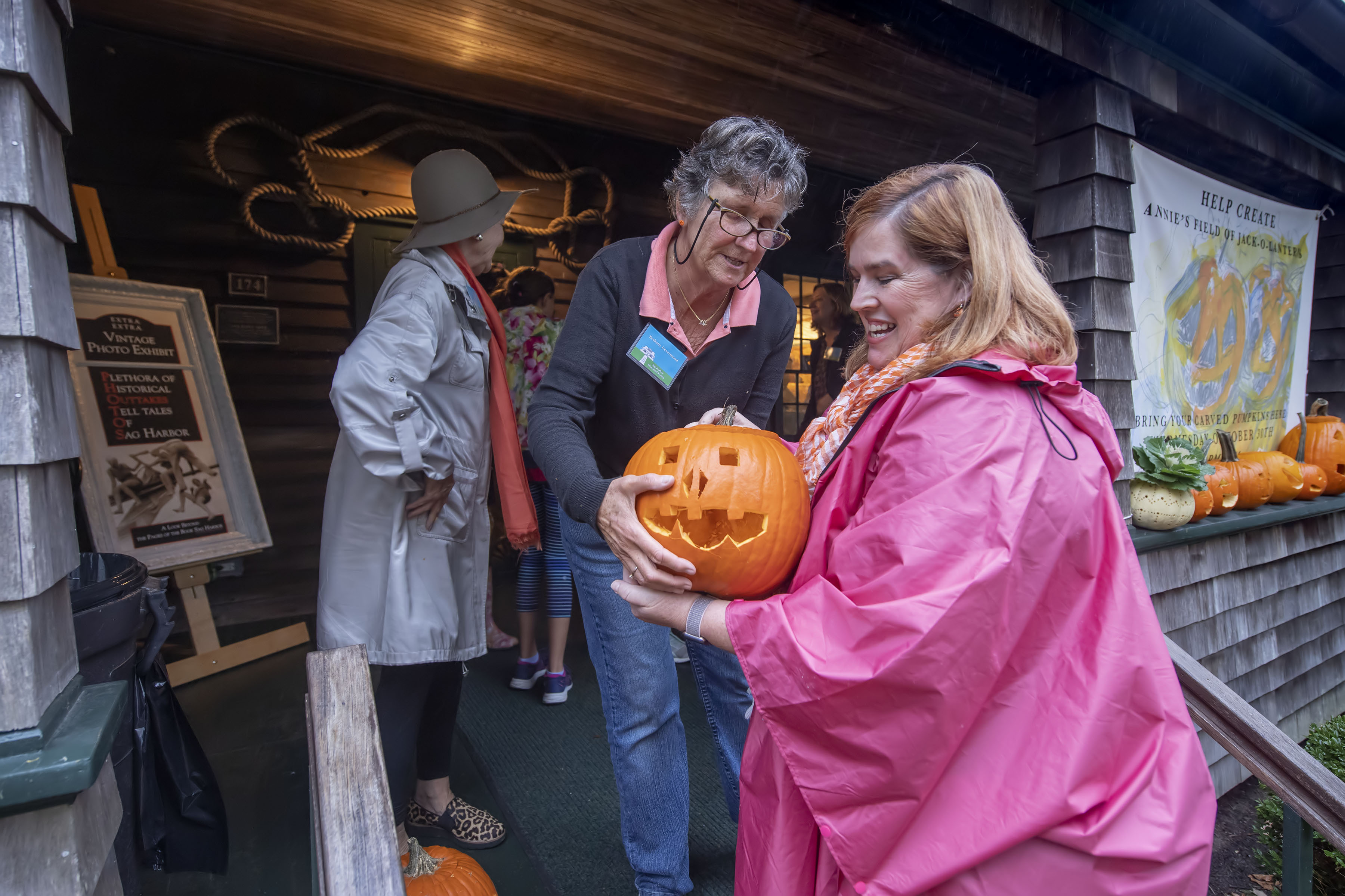 Bethany Deyermond accepts a new arrival from Julie Froehlich during the Annie's Field of Jack o' Laterns event hosted by the Sag Harbor Historical Society at the Annie Cooper Boyd House on Wednesday, October 30.  MICHAEL HELLER