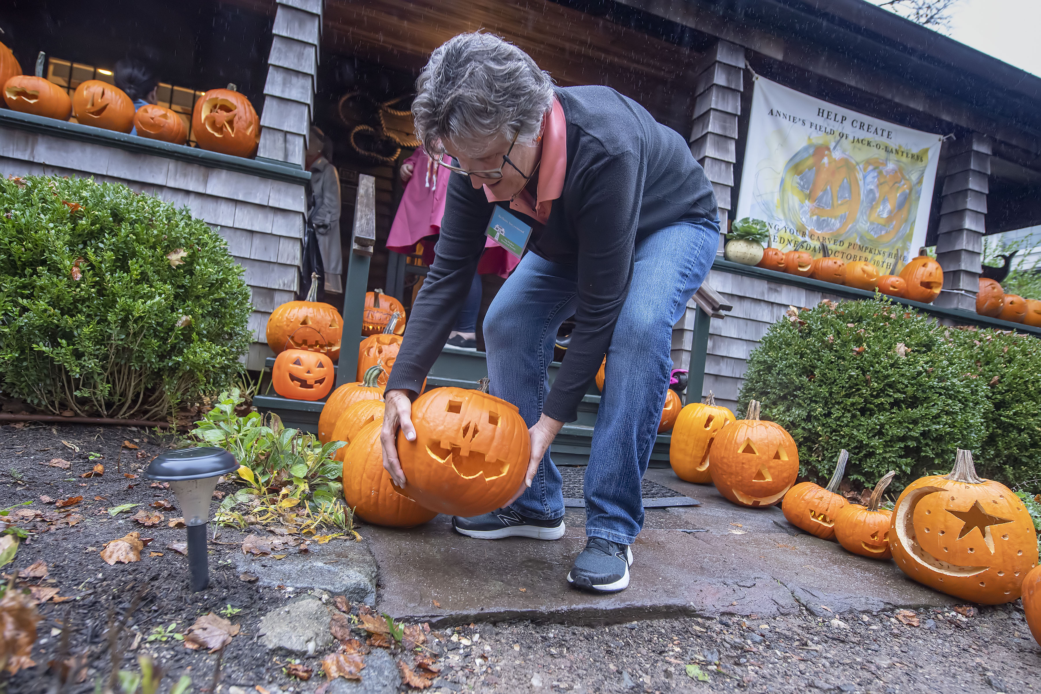 Bethany Deyermond places a new arrival into position during the Annie's Field of Jack o' Laterns event hosted by the Sag Harbor Historical Society at the Annie Cooper Boyd House on Wednesday, October 30.  MICHAEL HELLER