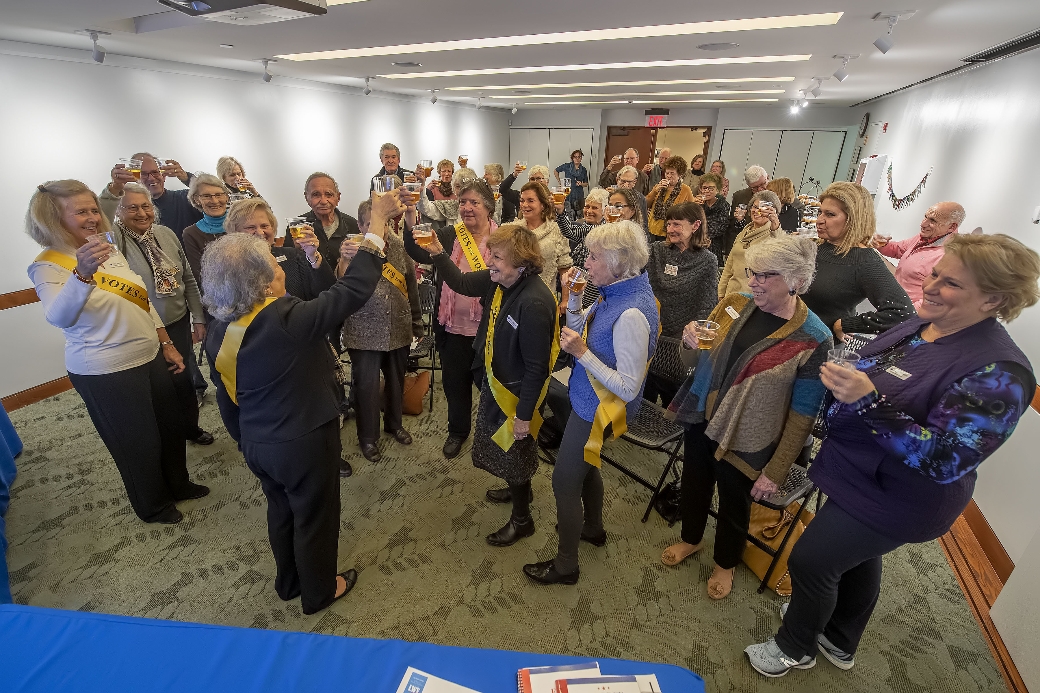 League officers and attendees raise their glasses in a toast during a gathering to celebrate of the 100th Anniversary of the League of Women Voters at the Hampton Library on Monday.