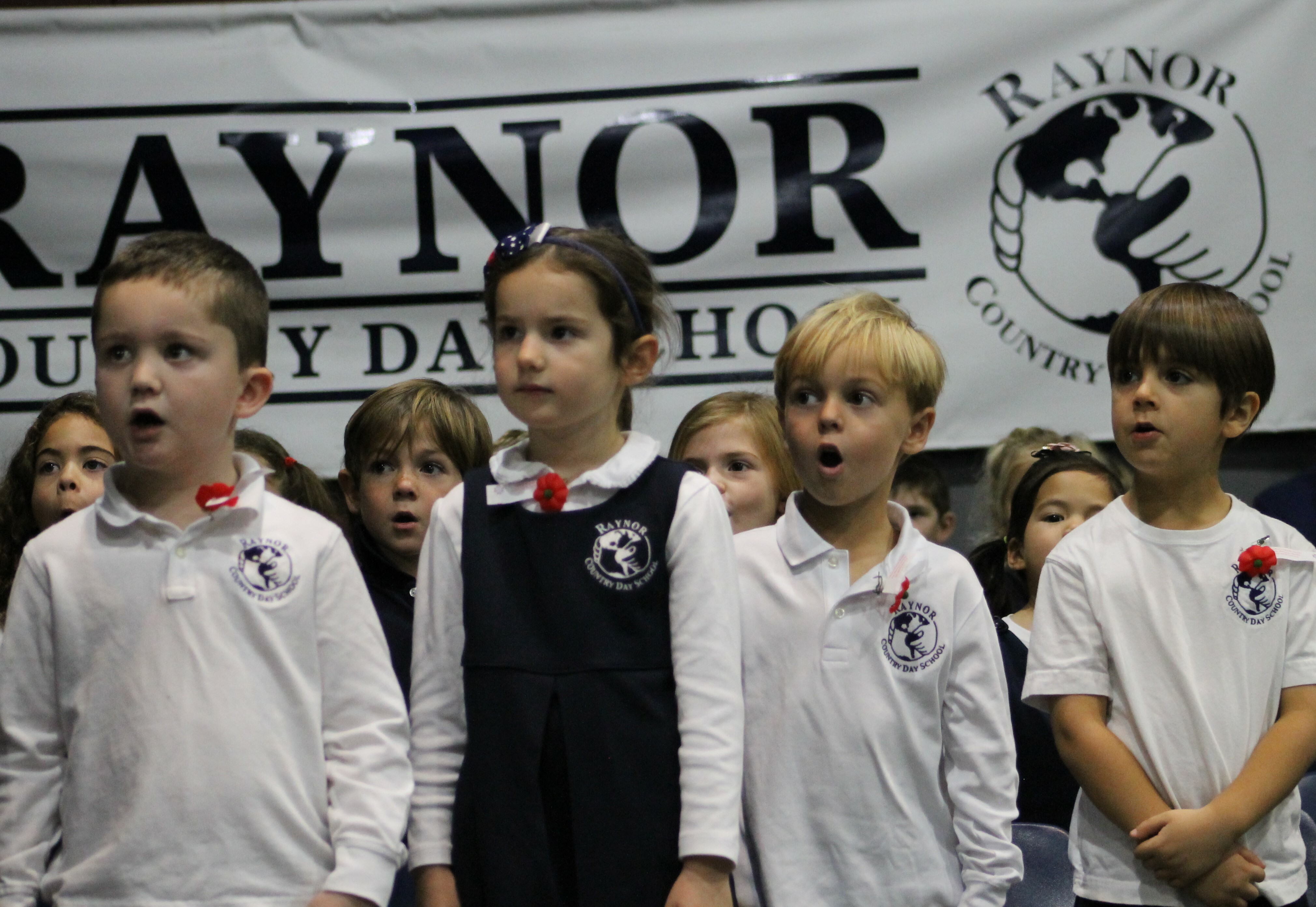 Kindergarten students, from left, C.J. Bale, Samantha Gorny, Miller Sumwalt and Levi Beaver perform God Bless America at Raynor Country Day School's annual Veterans Day ceremony.