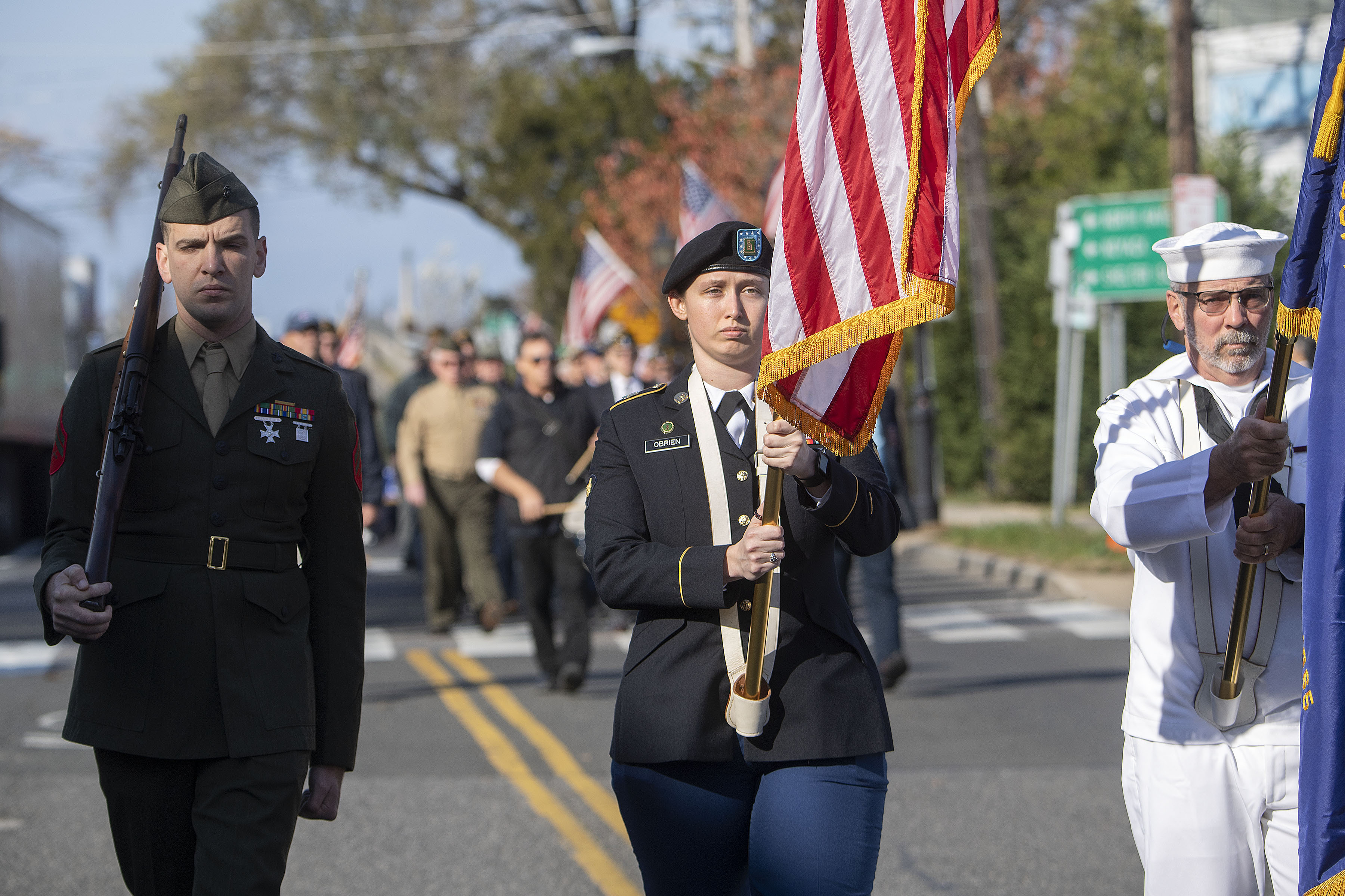 Bonnie O'Brien carries the American flag as Sag Harbor Veterans march down Bay Street during the 2019 Veterans Day Parade on Monday. MICHAEL HELLER