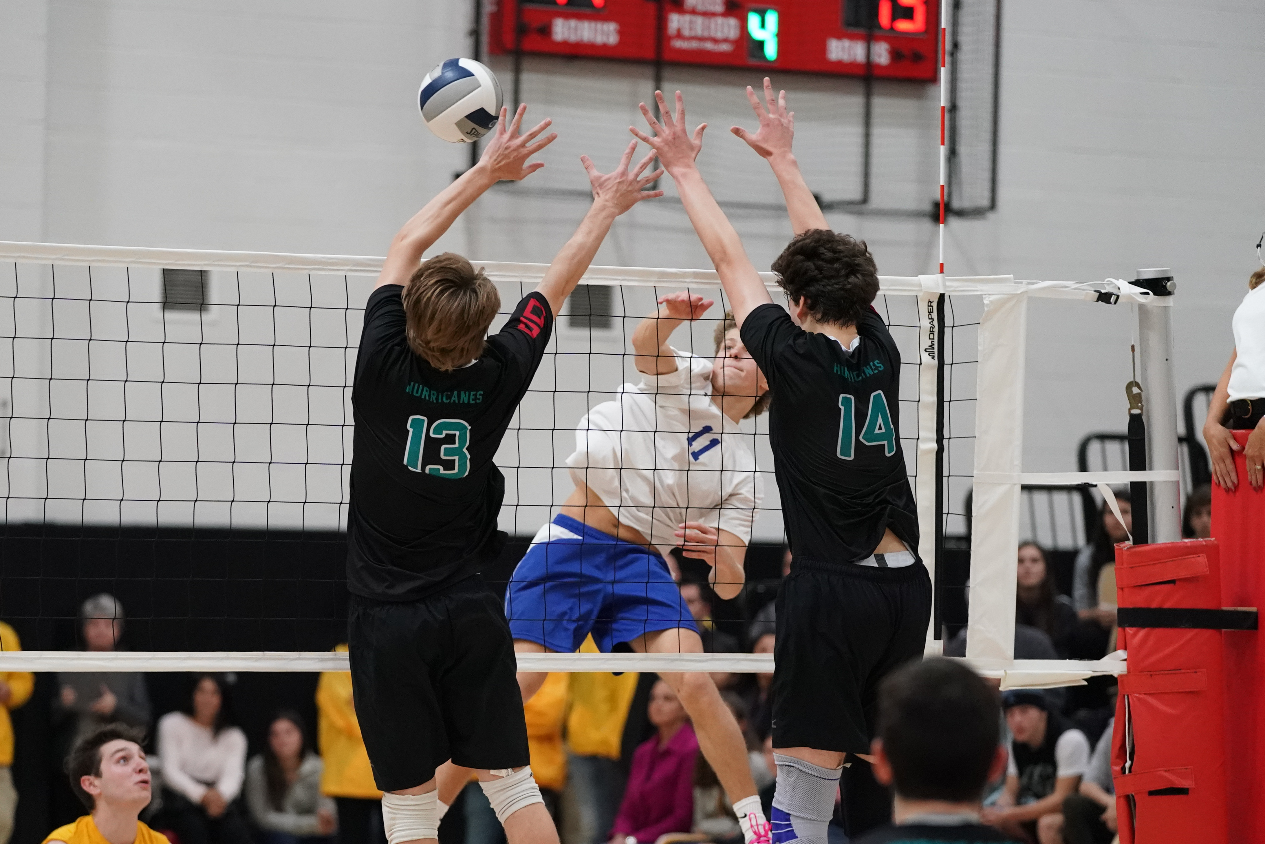 Micah Terry (13) and Daniel Haber get up to block Hauppauge's Chris Boudreau.