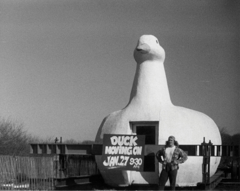 Dean Columbo next to sign announcing the relocation of the Big Duck, 1987 or 1988. COURTESY DEAN COLUMBO