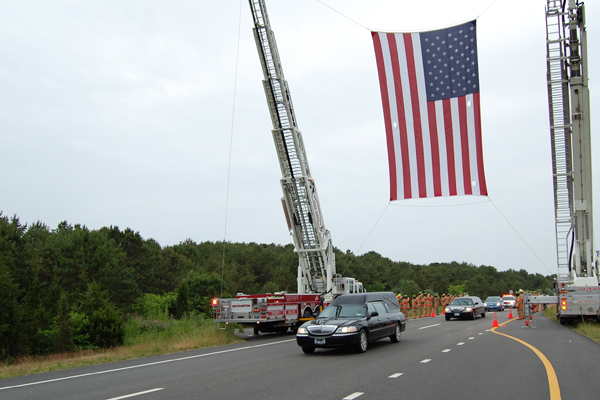  underneath an American flag hanged over the road by the Southampton Fire Department.<br>Photo by Brendan O'Reilly