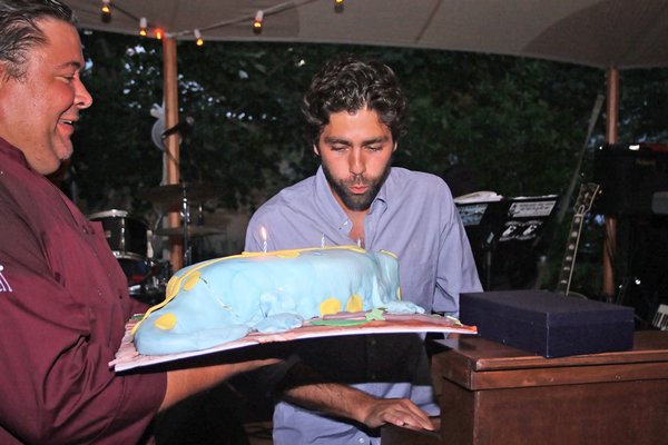 Adrian Grenier blows out the candles on his birthday cake.