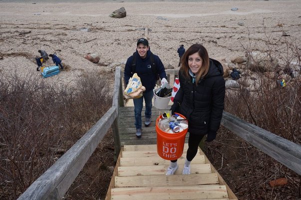 Volunteers carry debris from 67 Steps Beach in Greenport.. COURTESY ELI SURFRIDER FOUNDATION
