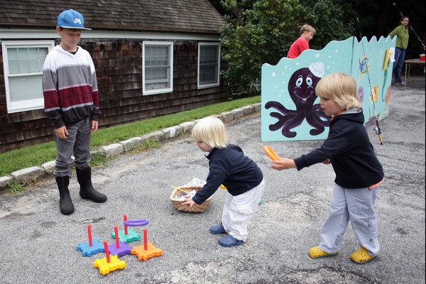 Liam and Bo Gunderson play the ring toss as Austin Hansen watches.