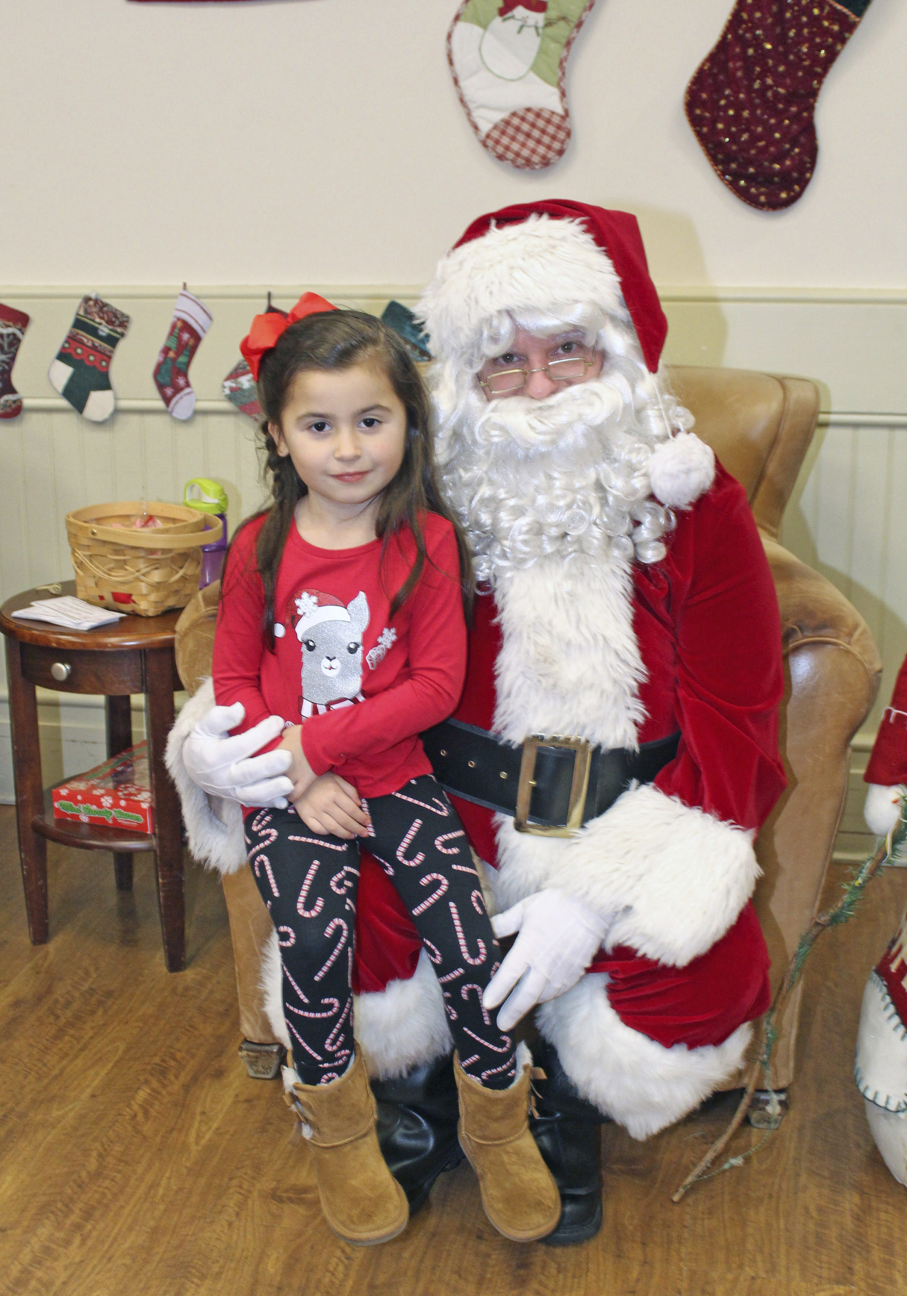 Annabelle Cardona visits with Santa at the Rogers Memorial Library on Saturday afternoon.    TOM KOCHIE