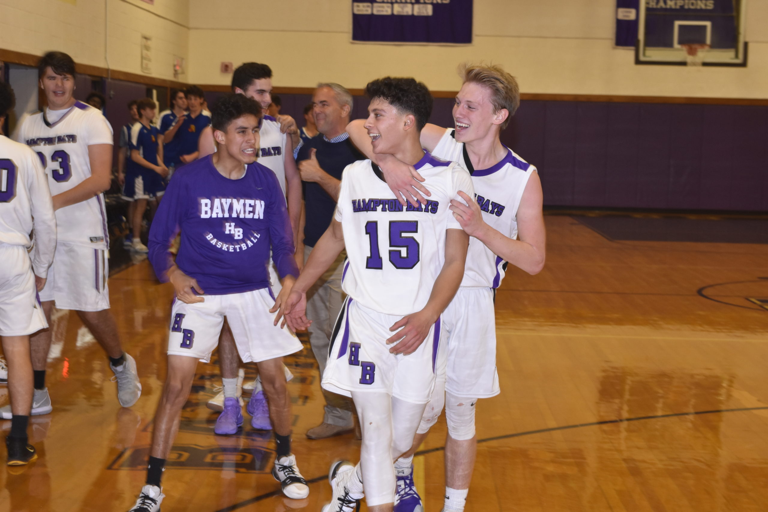 Lucas Brown and other teammates congratulate Steven Mora after his half-court buzzer beater led to a 54-51 victory over West Islip on Friday night.