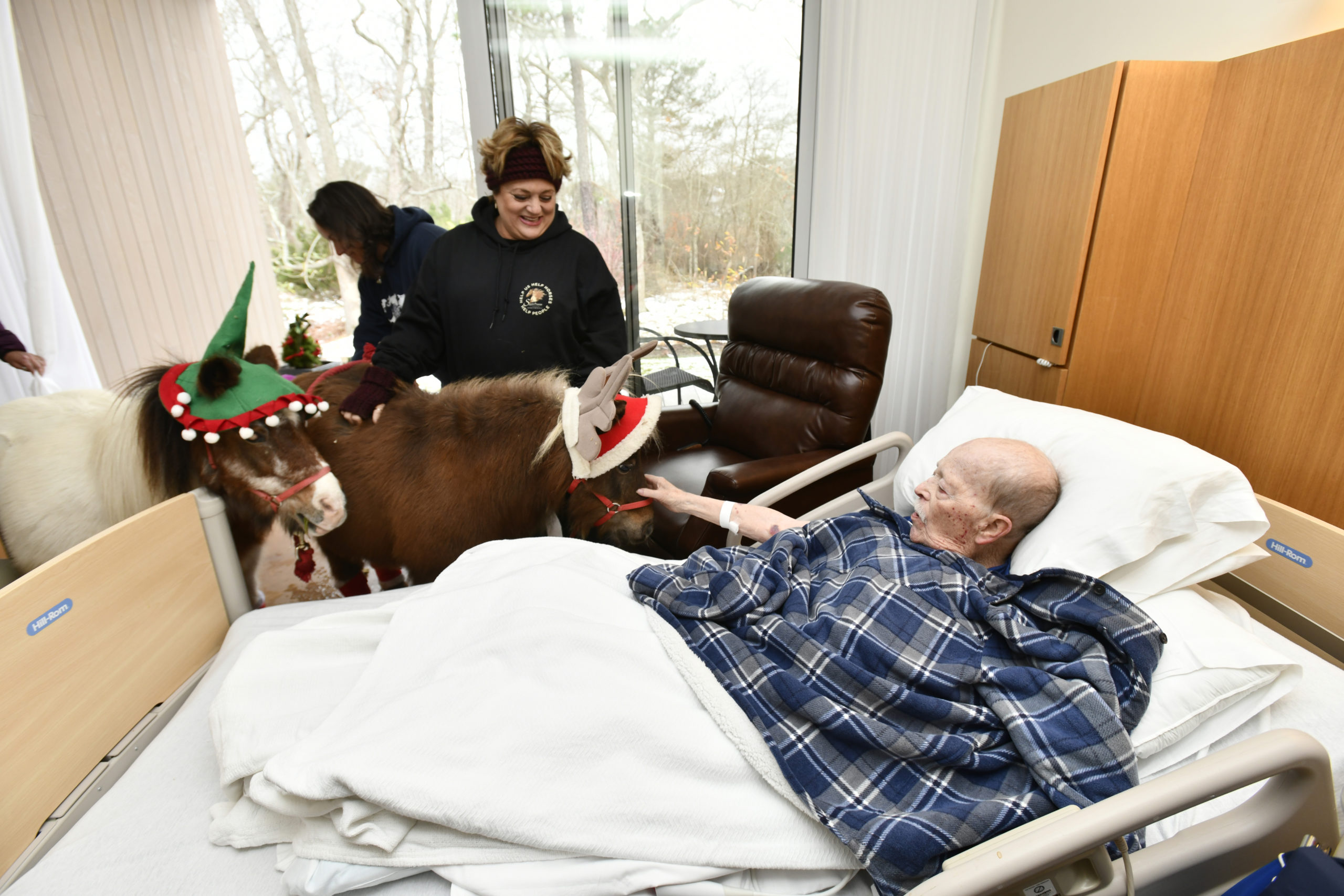 Daniel Byrne gets a visit from mini horses Sweetie and Christmas at the East End Hospice Kanas Center for Hospice Care on Wednesday, December 4.   DANA SHAW