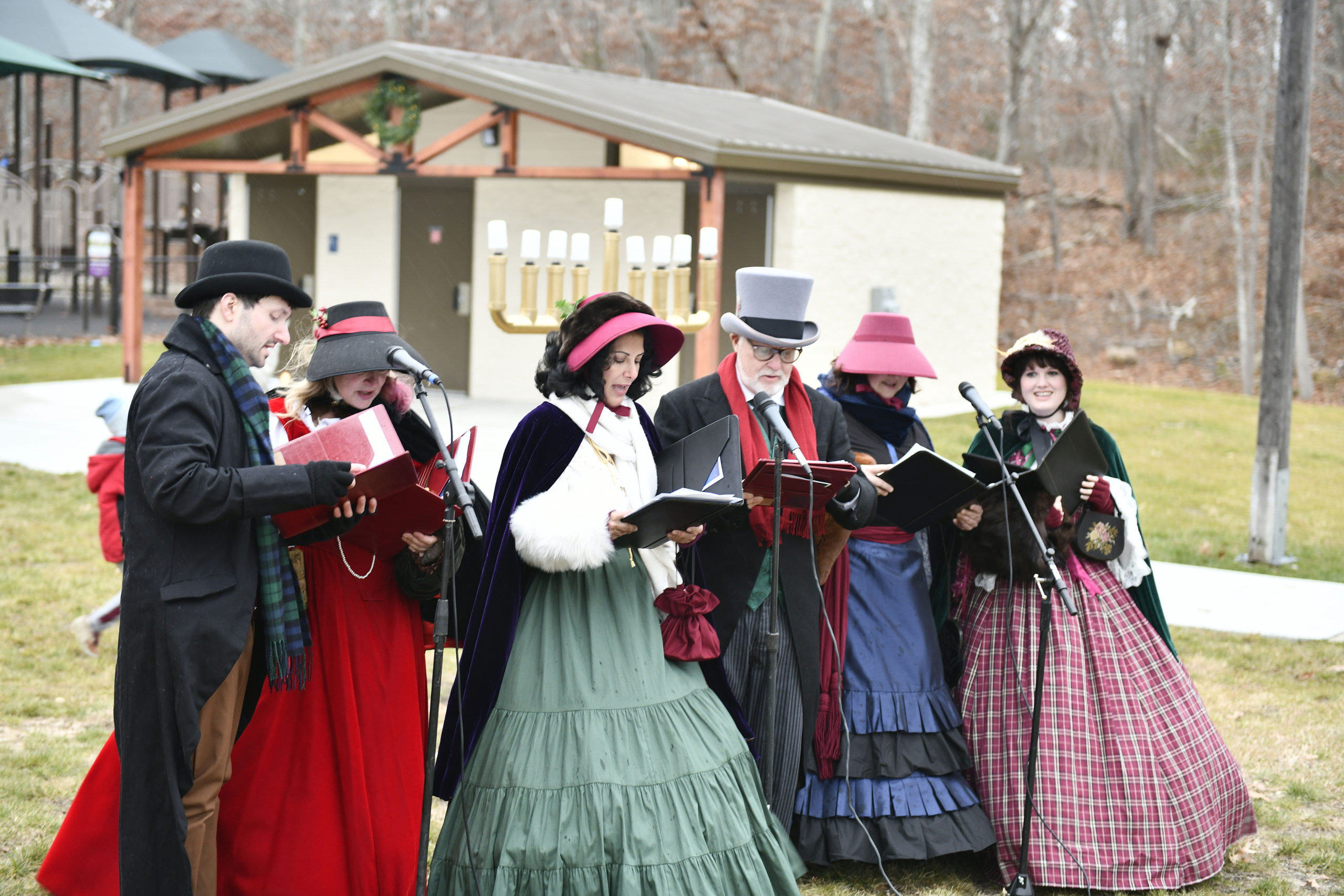 Festivities were cut short due to the rain but that didn't stop the Grinch, the Dickens Carolers and visitors from singing a quick carol and lighting the tree at Good Ground park in Hampton Bays on Friday.  DANA SHAW