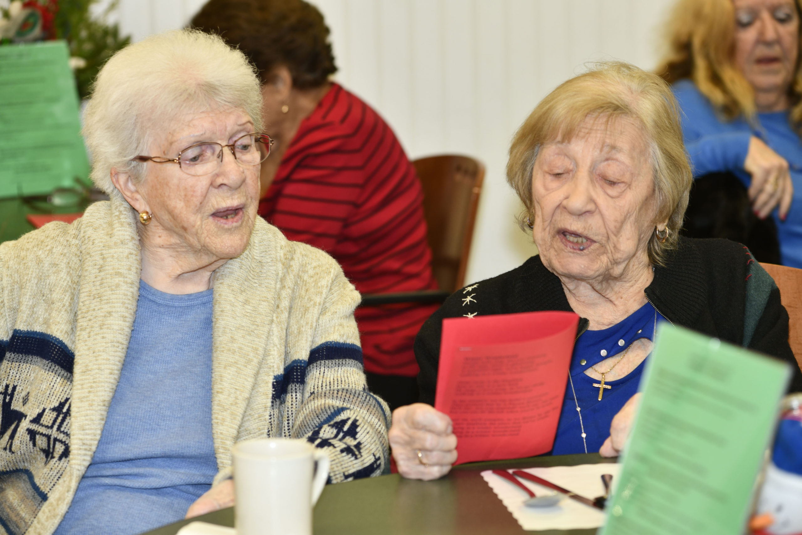 Hetty Aufhauser and Mary Palmisano sing a carol.