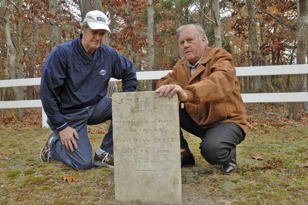 Dennis Delaney and  Zach Studenroth with Samuel E. Robinson's gravestone in the Squires (Fournier) Burying Ground Hampton Bays.  DANA SHAW