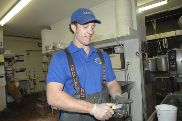 Cutter Koster shucks scallops at the Clamman in Southampton. DANA SHAW