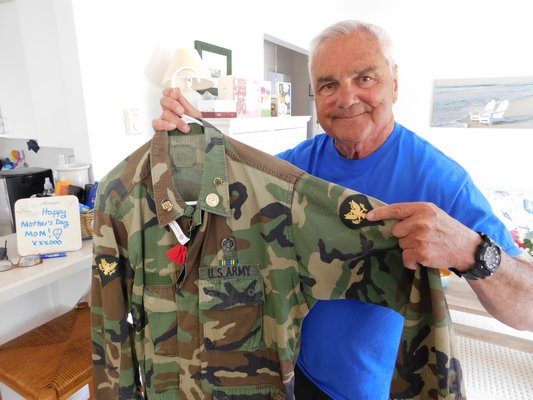 Louis Mosconi holding the jacket he wore during the Korean War at his house in Montauk.  ELIZABETH VESPE
