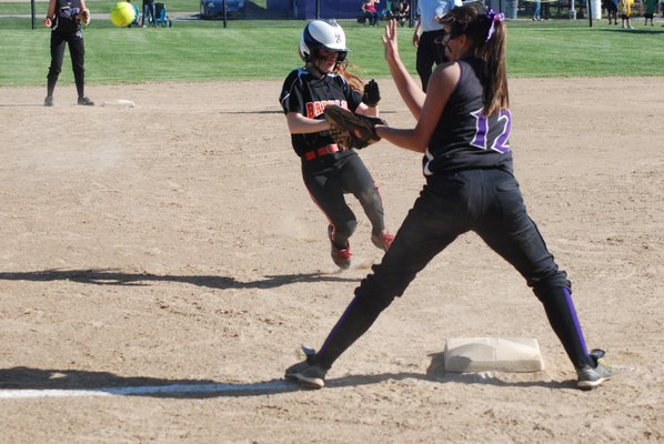 Hampton Bays sophomore Rebecca Harris tries to field a hopper as Cierra Smith of Center Moriches steals second base. BY DREW BUDD