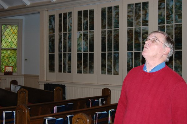 Pastor Jack King of the Beach United Methodist Church looks up at the ceiling in the church. The roof is in disrepair and the congregation is collecting money to pay to fix it. 