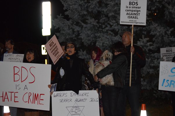 About 60 members of the South Fork community gathered in front of Bay Street Theater on Friday night to protest Roger Waters's performance. ALISHA STEINDECKER