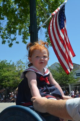Southampton Village drew a large crowd for the annual Fourth of July parade. Clara Harvey got a boost onto a mailbox on Main Street.